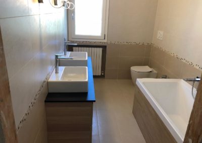 Bagno con piastrelle chiare ed inserto mosaico