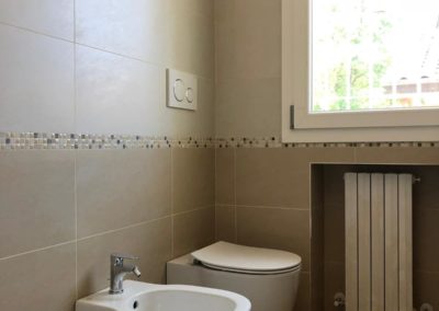 Parete bagno con sanitari e piastrelle in gres porcellanato color beige