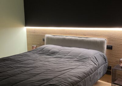 camera da letto moderna e di design con piastrelle effetto legno in pavimento e parete