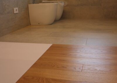 bagno padronale con pavimento in legno e gres effetto pietra